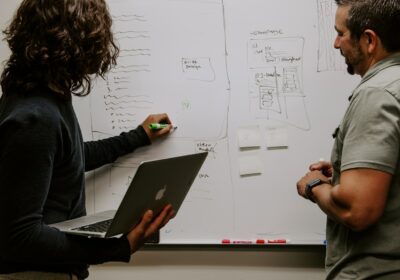 man wearing gray polo shirt beside dry-erase board