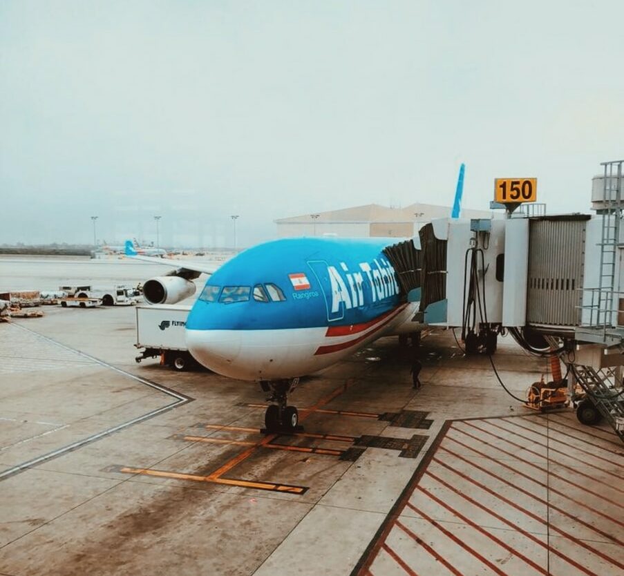 white and blue passenger plane on concrete ground